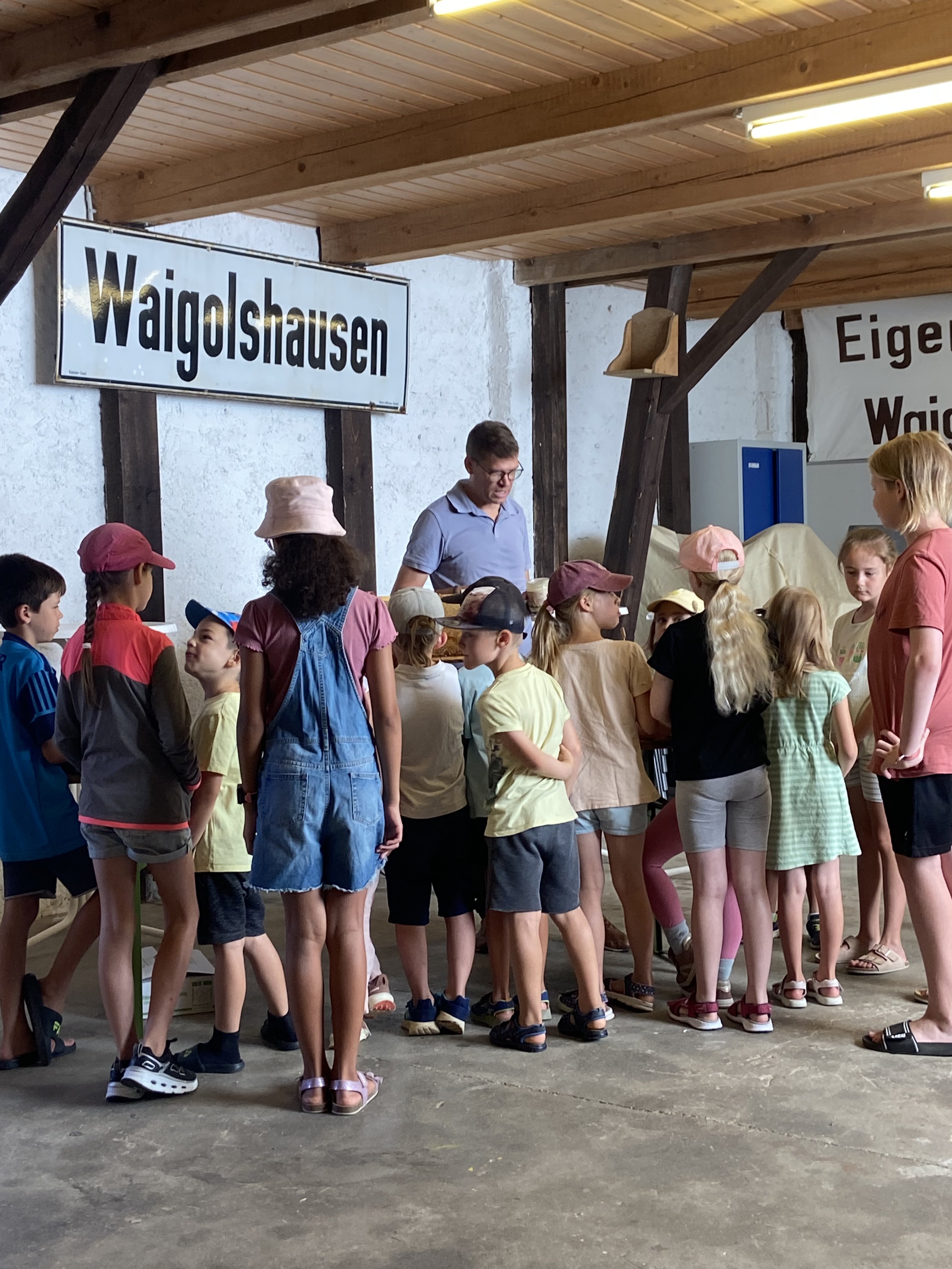 Teilnehmende Kinder und Imker Jürgenwolf in der Vereinshalle der Eigenheimer in Waigolshausen beim Ferienspaß