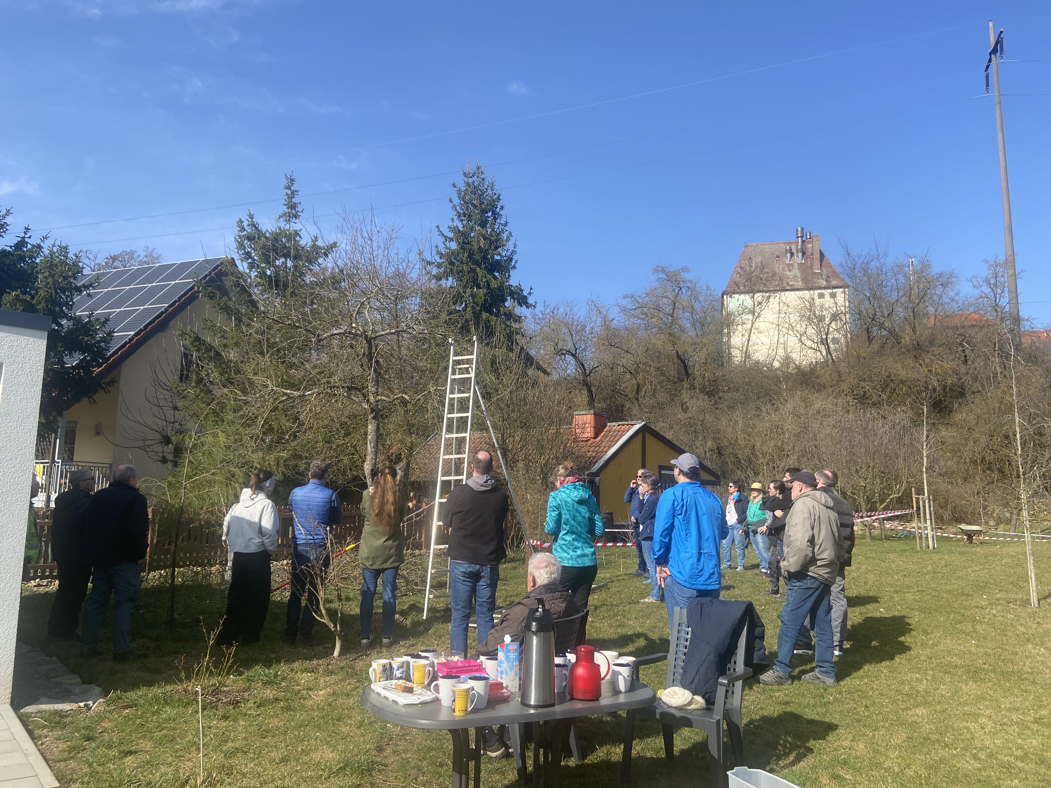 Teilnehmer beim Baumschnittkurs in Waigolshausen. Gruppe von hinten. Im Vordergrund Kaffee und Kuchen.